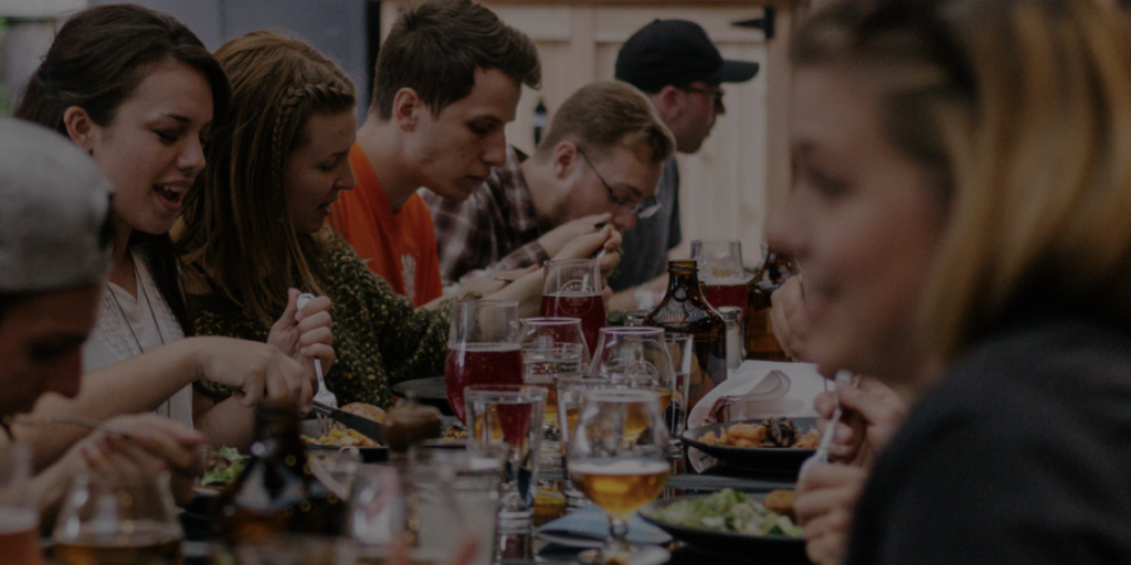 Group of people happily sitting together at a table dining together